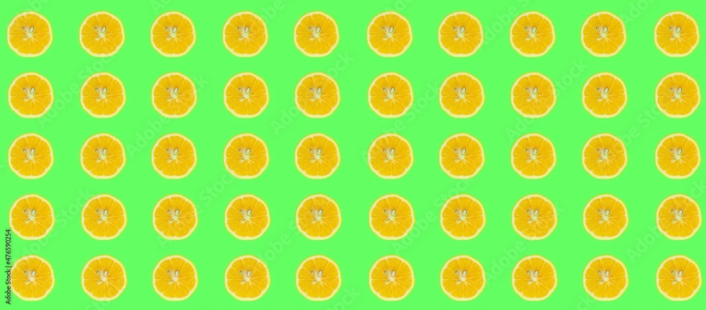 Lemon slices pattern, top view of lemon slices isolated on a green background.