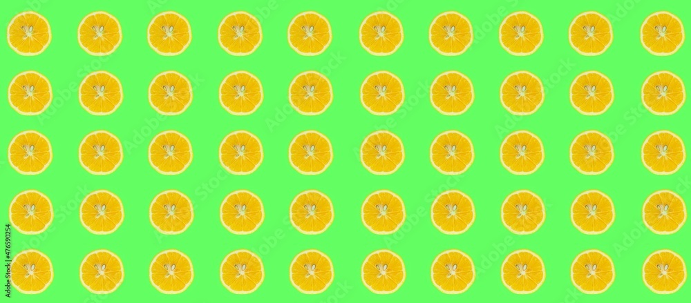 Lemon slices pattern, top view of lemon slices isolated on a green background. Lemon slices pattern, top view of lemon slices isolated on a green background.