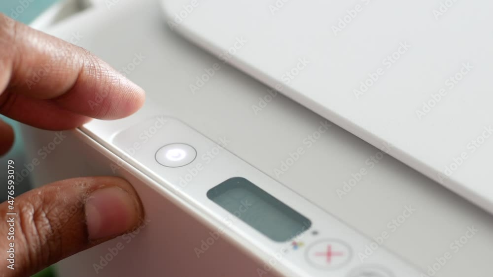 hand pressing button on printer close up hand pressing button on printer close up