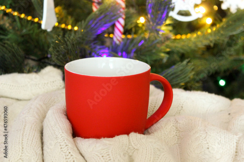Blank red mug with christmas tree on background,mat tea or coffee cup with christmas and new year decoration,vertical mock up with ceramic mug for hot drinks,empty gift print template.