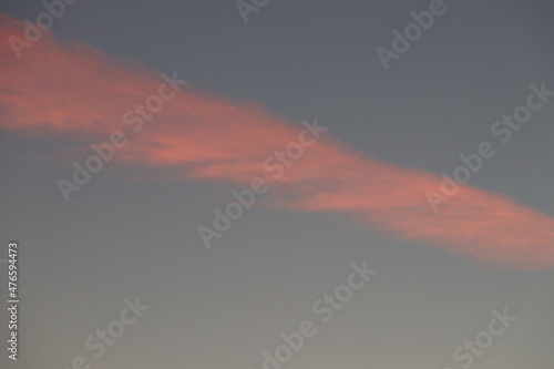 Calming picture of a red cloud during the sunrise against a tranquil colored soothing morning sky © Timothy