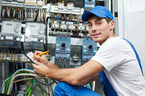 Canvas electrician worker inspecting equipment and electricity meter