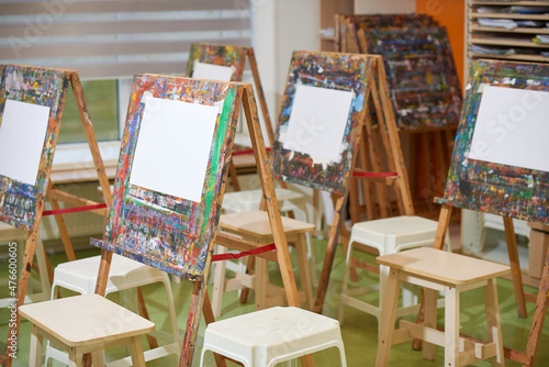 Old soiled easels with white drawing sheets in school class