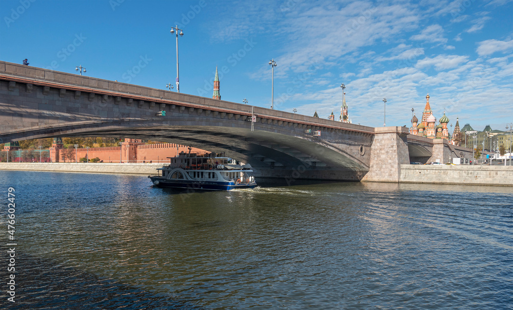 Bolshoi Moskvoretsky Bridge and a pleasure boat under it, floating on the Moskva River in Moscow.