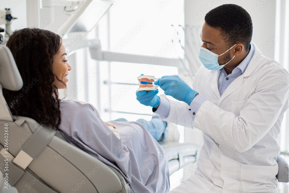 Dental Hygiene. Dentist Holding Jaw Model And Showing How To Brush Teeth