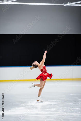 Photography full length of happy figure skater with raised hands doing layback in profession