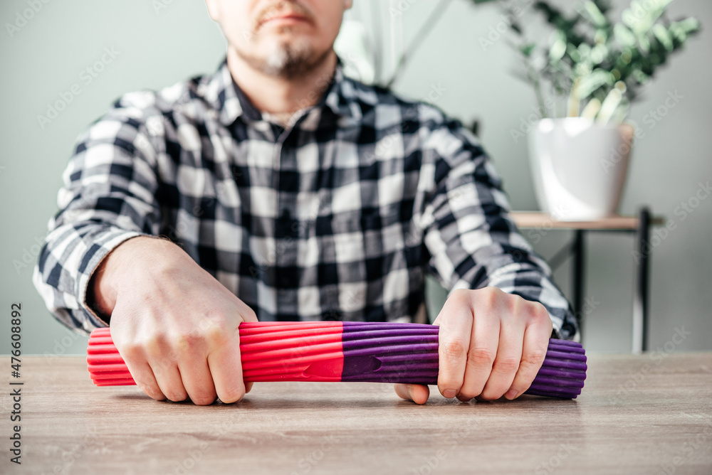 A man doing wrist exercises with theraband flexbar Stock Photo