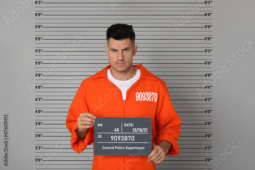 Fotografia Prisoner with mugshot letter board at police department