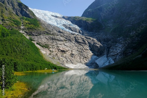 Fototapeta Naklejka Na Ścianę i Meble -  Boyabreen Glacier and a glacial lake  Jostedalsbreen National Park  in Norway. A small tent stands at the foot of the glacier.