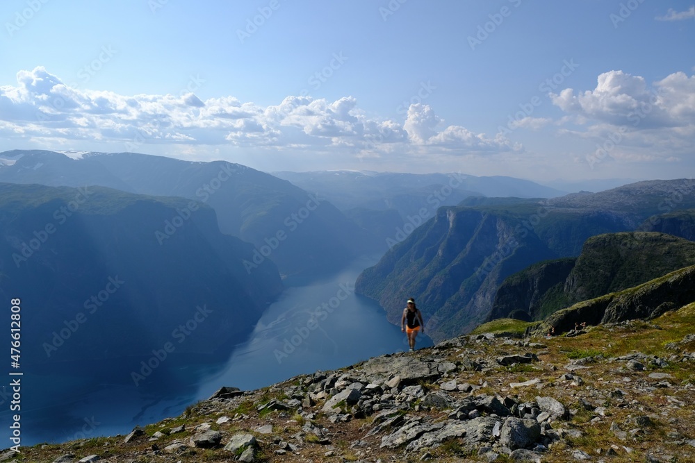 Amazing scenery of Aurlandsfjord from top of Priest Røyrgrind. Blurry silhouette of a woman in motion on top. Aurlandsfjord is one of most beautiful fjords in Norway.