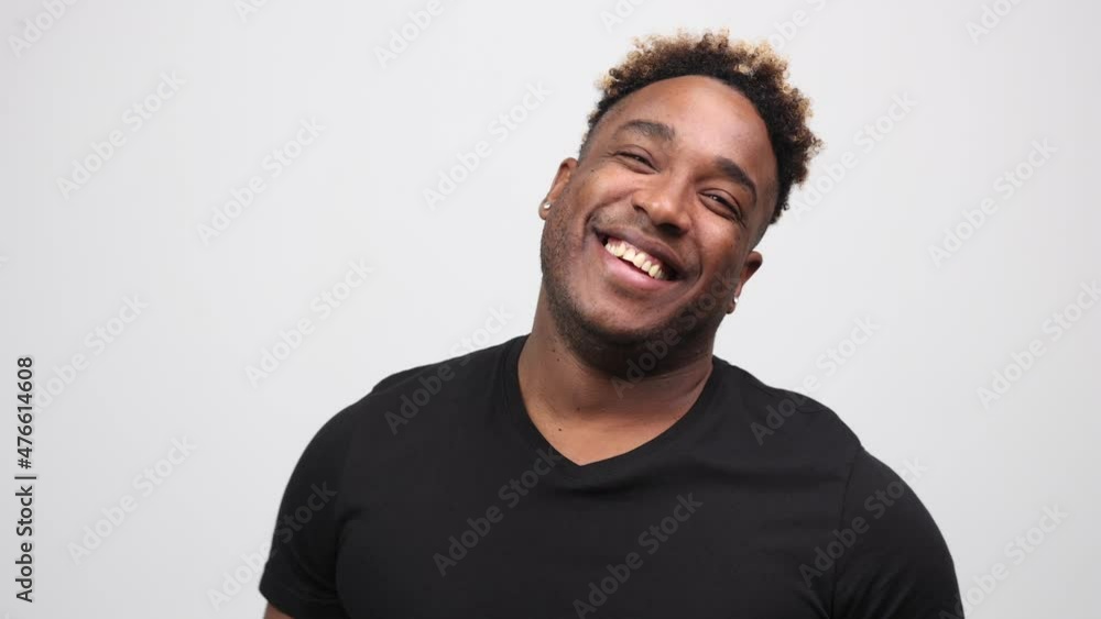 Studio portrait of a confident smiling young black man laughing on a white background - 4k video in slow motion. Sincere emotions of joy and fun Studio portrait of a confident smiling young black man laughing on a white background - 4k video in slow motion. Sincere emotions of joy and fun