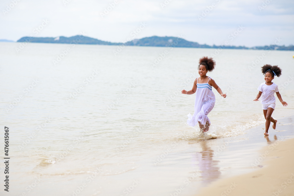Two African girl playing on the beach during holiday.