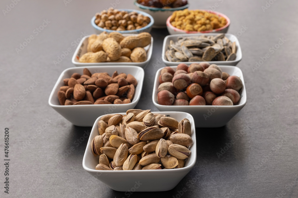 Pistachio in selective focus. Background of dried mulberry, hazelnut, pistachio, grape, almond, yellow chickpea and sunflower seeds. Pistachio in selective focus. Background of dried mulberry, hazelnut, pistachio, grape, almond, yellow chickpea and sunflower seeds.