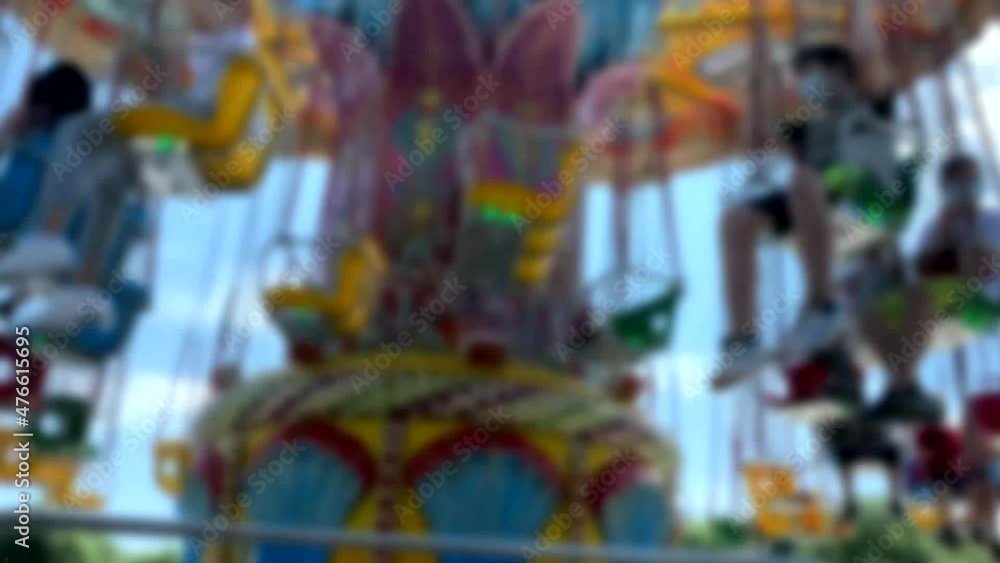 Large Colourful Carousel at the park on blue sky background. Blurred view. 4K Large Colourful Carousel at the park on blue sky background. Blurred view. 4K