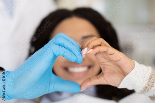 Closeup Of Dentist Doctor And Female Patient Making Heart Gesture With Hands photo