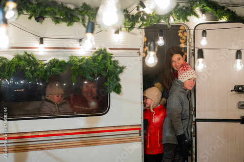 Happy large family celebrates christmas in nature. Parents with three sons travels in a mobile home. 