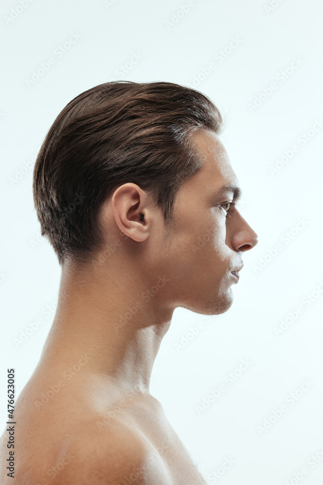 Profile view of young handsome man isolated on white studio background. Concept of men's health and beauty Profile view of young handsome man isolated on white studio background. Concept of men's health and beauty