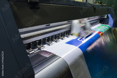 Large format inkjet printer working on vinyl paper in workplace
