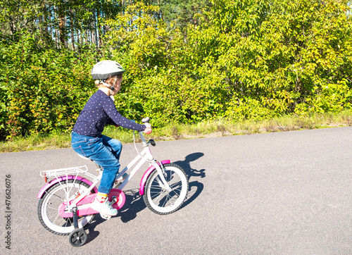 Cycling ride. A child, 5 years old Caucasian girl, rides a bicycle. A child in a bicycle helmet.