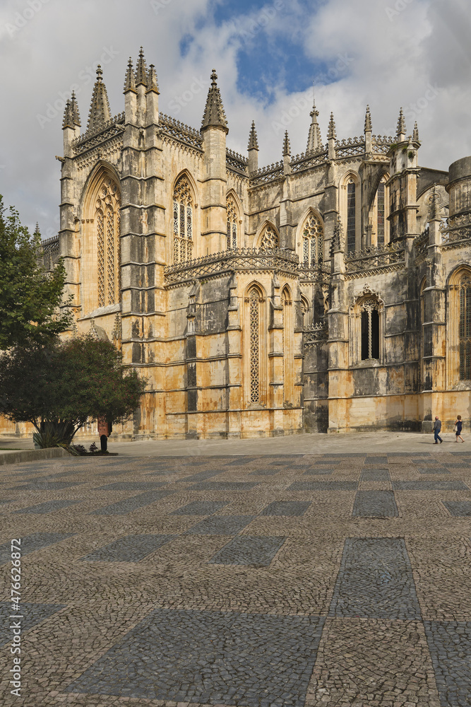 the western façade of the Batalha Monastery facing the large square with its equestrian statue of general Nuno Álvares Pereira in Batalha, Portugal