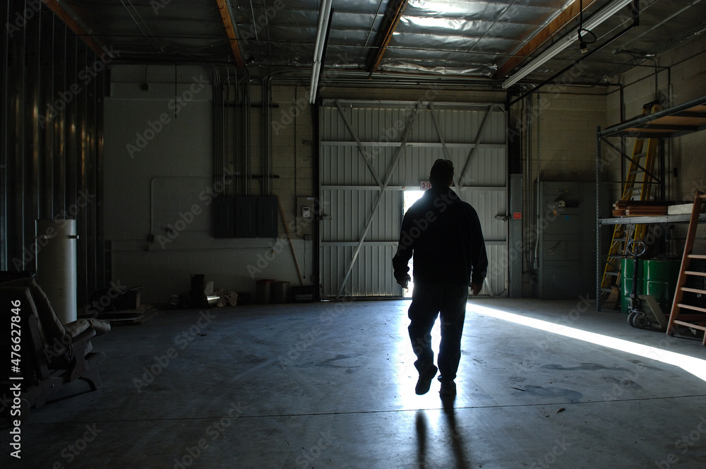 Man walking through empty warehouse.