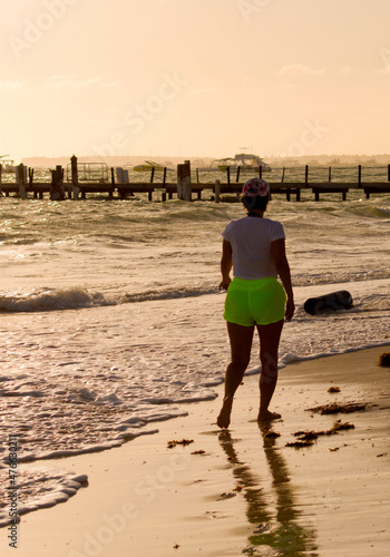 woman walking at sunset on the Bávaro beach, Punta Cana, Dominican Republic