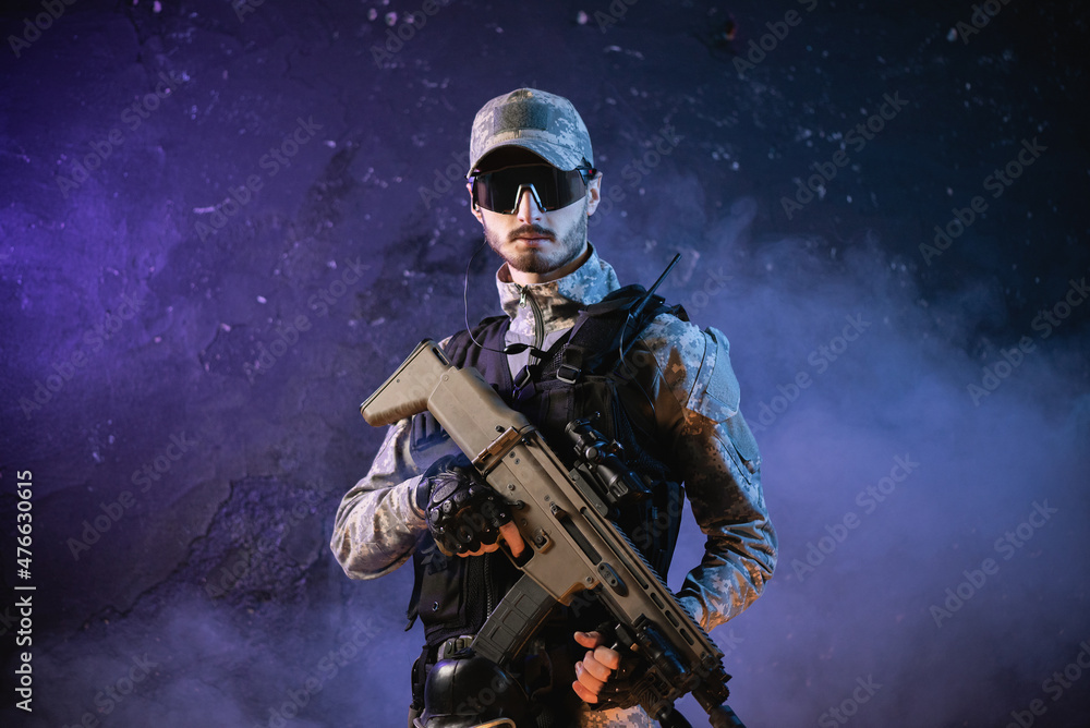 Fototapeta premium Futuristic soldier with a rifle on the black smoky background.