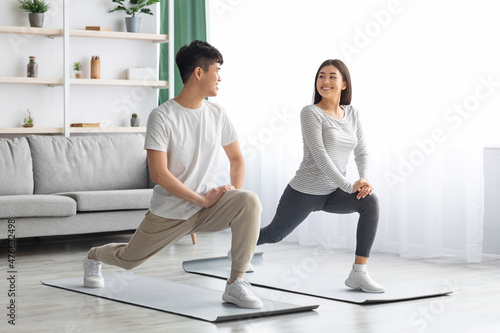Happy asian couple exercising at home, copy space