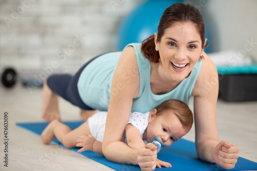 woman ane baby boy exercising on floor at home photo