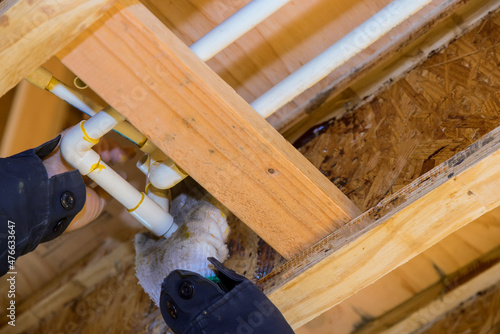 The worker is using a glue PVC pipe for installing the water pipe photo