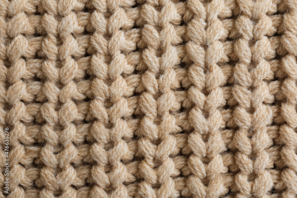 Beautiful beige knitted fabric as background, top view Beautiful beige knitted fabric as background, top view