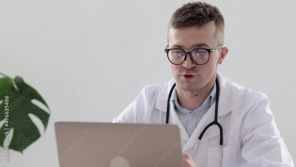 European doctor in a clinic talking to a patient via video link, a Caucasian doctor in an office in a hospital diagnoses a patient via a webcam, telemedicine. doctor-patient communication in European doctor in a clinic talking to a patient via video link, a Caucasian doctor in an office in a hospital diagnoses a patient via a webcam, telemedicine. doctor-patient communication in