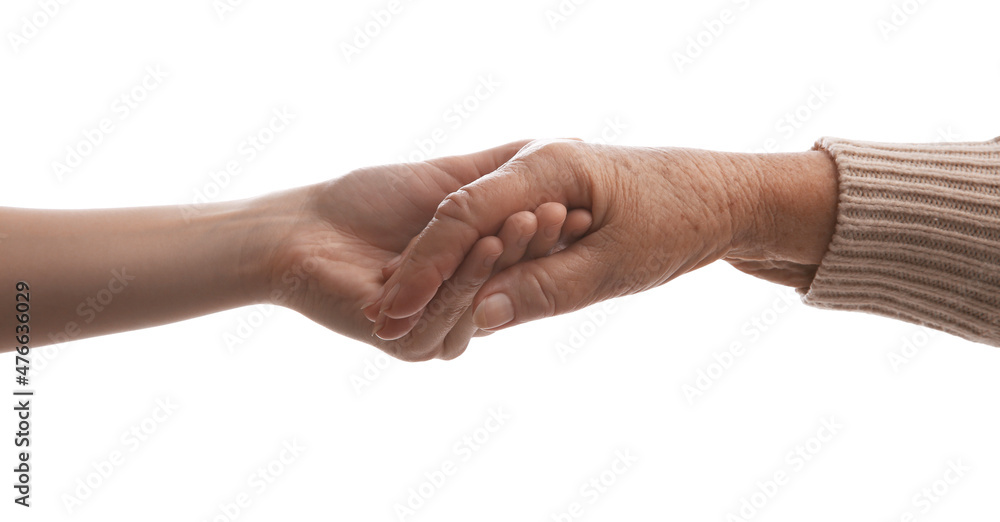 Young and elderly women holding hands together on white background, closeup Young and elderly women holding hands together on white background, closeup