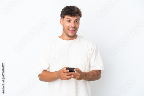 Young caucasian handsome man isolated on white background surprised and sending a message