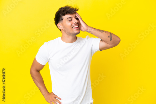 Young caucasian handsome man isolated on yellow background smiling a lot