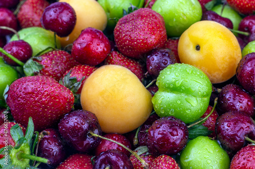 Fototapeta Naklejka Na Ścianę i Meble -  Ripe strawberry, apricot, cherry, green plum with water drops. Fresh Summer fruit background close up image.
