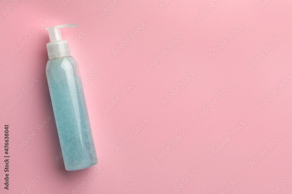 Bottle of blue cosmetic gel on pink background, top view. Space for text Bottle of blue cosmetic gel on pink background, top view. Space for text