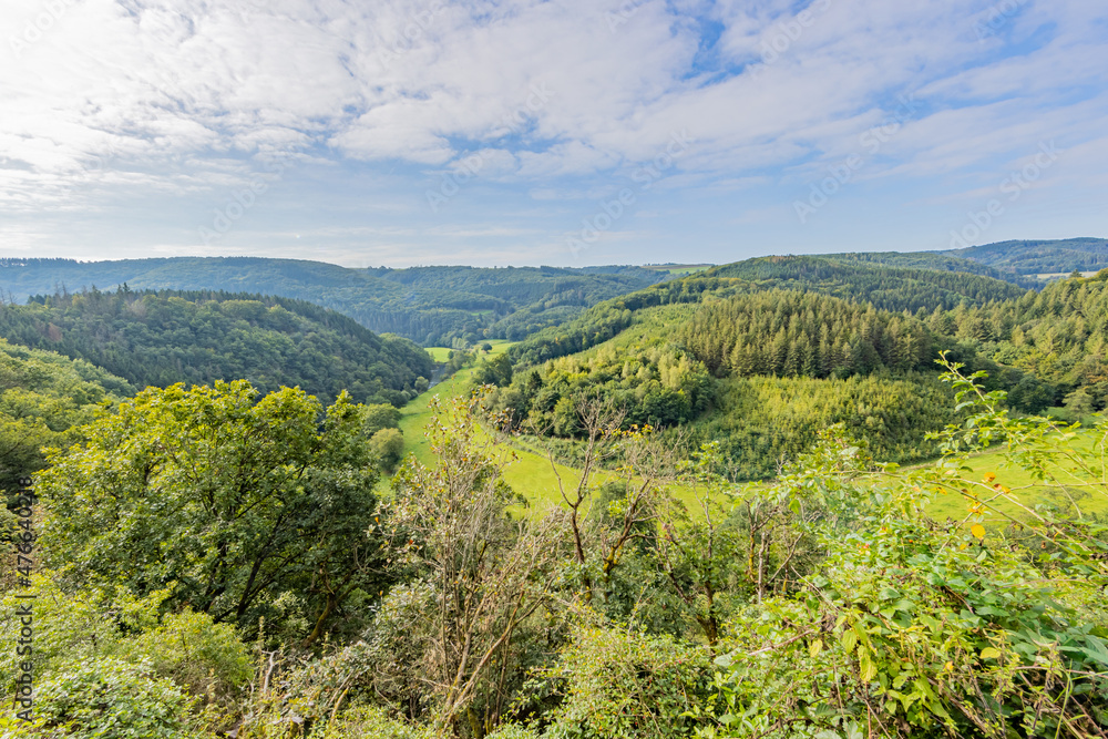 Aerial view of the valley with mountains and hills covered with lush green trees with the horizon in the background, sunny summer day with a spectacular blue sky with abundant white clouds, Luxembourg Aerial view of the valley with mountains and hills covered with lush green trees with the horizon in the background, sunny summer day with a spectacular blue sky with abundant white clouds, Luxembourg