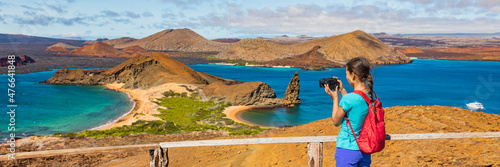 Galapagos islands ecotourism travel banner. Bartolome Island, tourist hiking in the Islas Galapagos archipelago. Panoramic view of Sullivan bay, golden beach and Santiago island on cruise excursion. photo