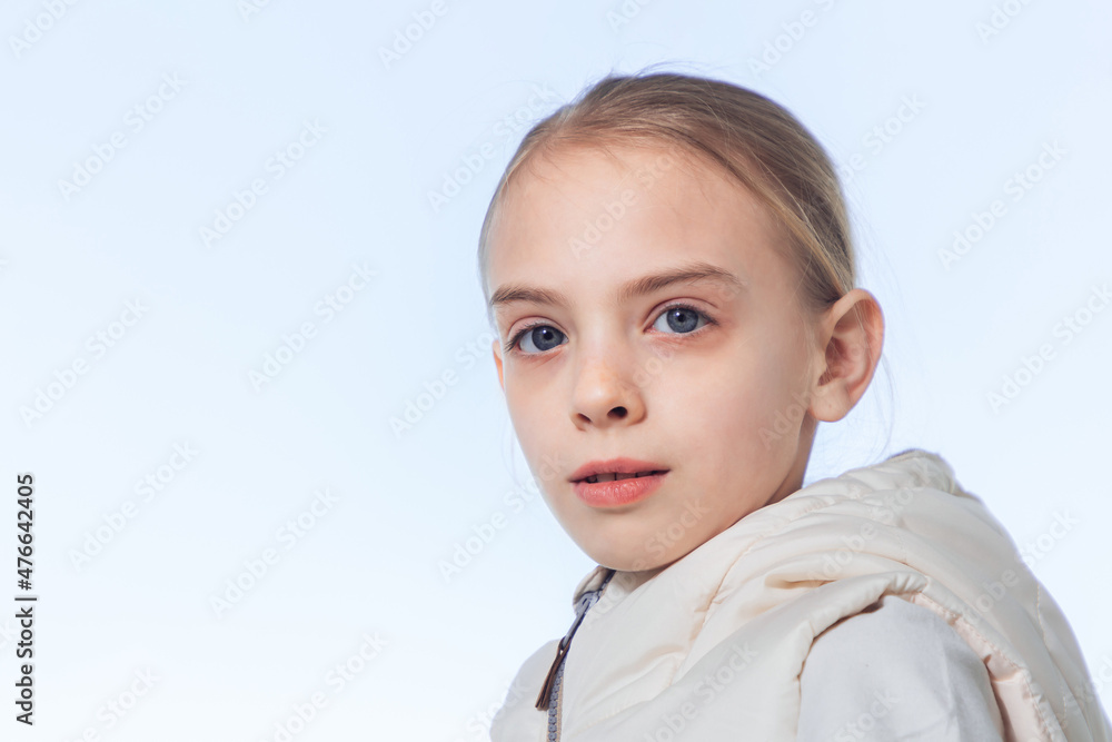 Portrait of a young girl with blonde hair against a blue sky, outdoors. Portrait of a young girl with blonde hair against a blue sky, outdoors.