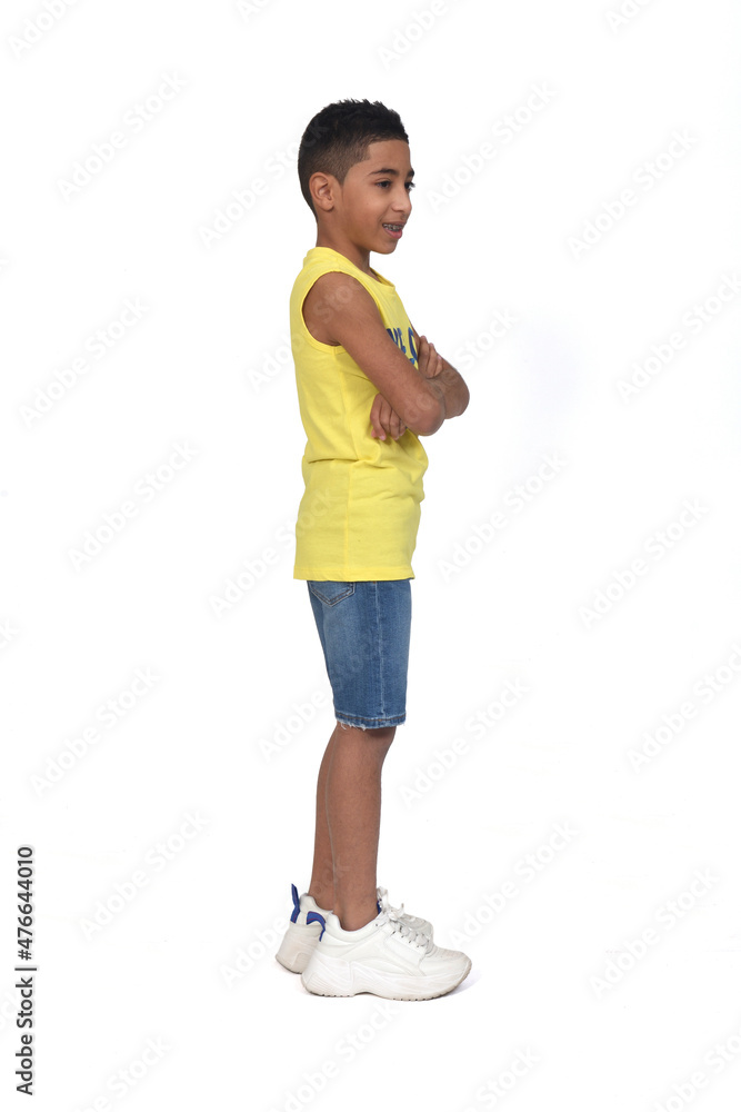 side view of a full portrait of a boy dressed in shorts and sleeveless with arms crossed and looking awayon white background side view of a full portrait of a boy dressed in shorts and sleeveless with arms crossed and looking awayon white background