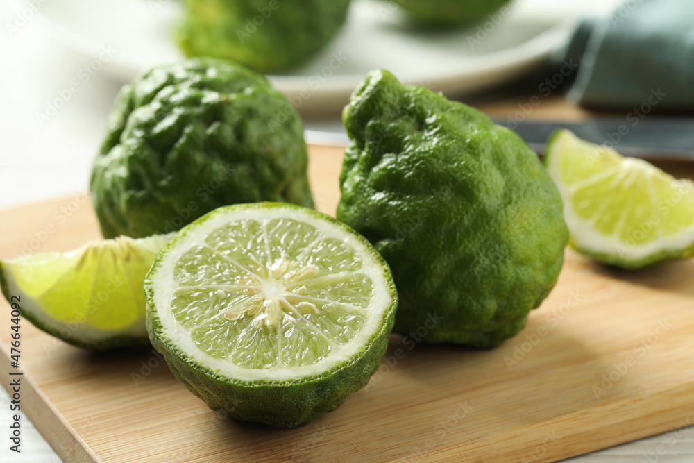 Whole and cut ripe bergamot fruits on wooden board, closeup Whole and cut ripe bergamot fruits on wooden board, closeup