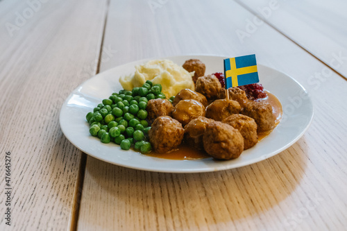  woman eating Swedish traditional meatballs with fried potatoes and cranberry sauce. Swedish food concept. photo