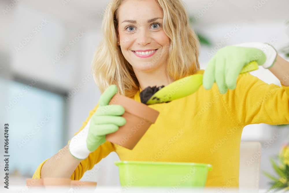 woman holding pot and trowel for transplanting plants woman holding pot and trowel for transplanting plants