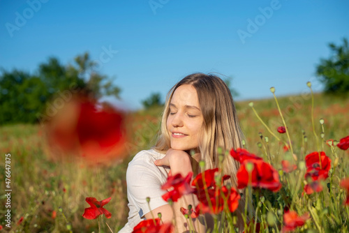 junge Frau genießt Sonne im Mohnfeld