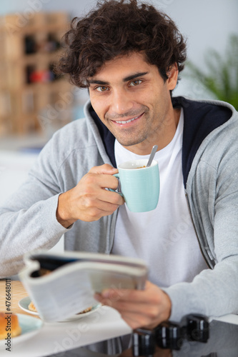 young man having breakfast at home photo