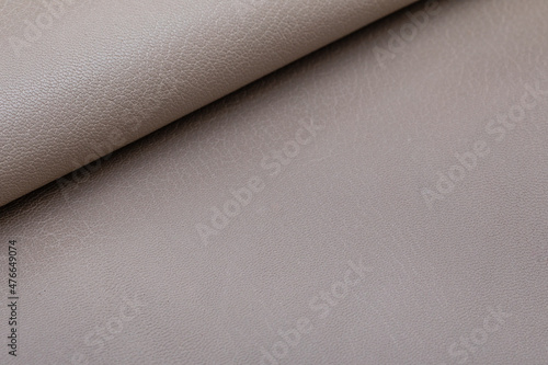 Grey folded natural cow leather on the wooden table  