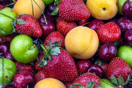 Fresh Summer fruit background. Ripe strawberry  apricot  cherry  green plum close up image.