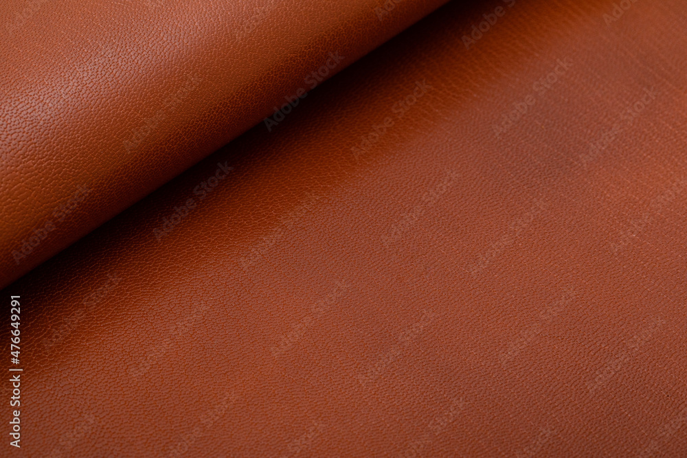 Fototapeta premium Brown glossy folded natural cow leather on the wooden table