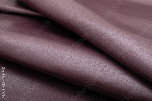 dyed metallic purple glossy folded natural cow leather on the wooden table 